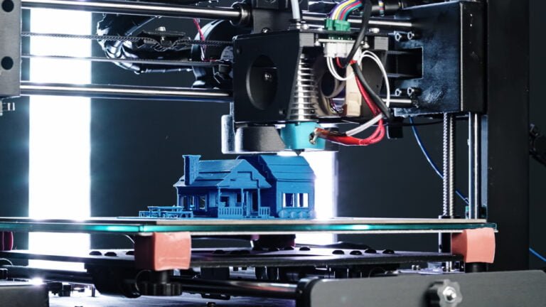 A 3D printer in action, creating a house, highlighting advancements in construction technology.