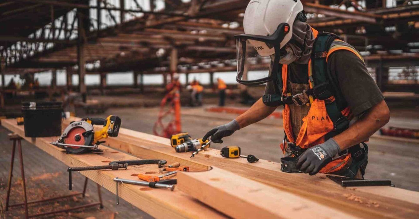 A man skillfully working on a wooden plank in a Cambodian factory, showcasing the need for Labor Market in Cambodian Construction.