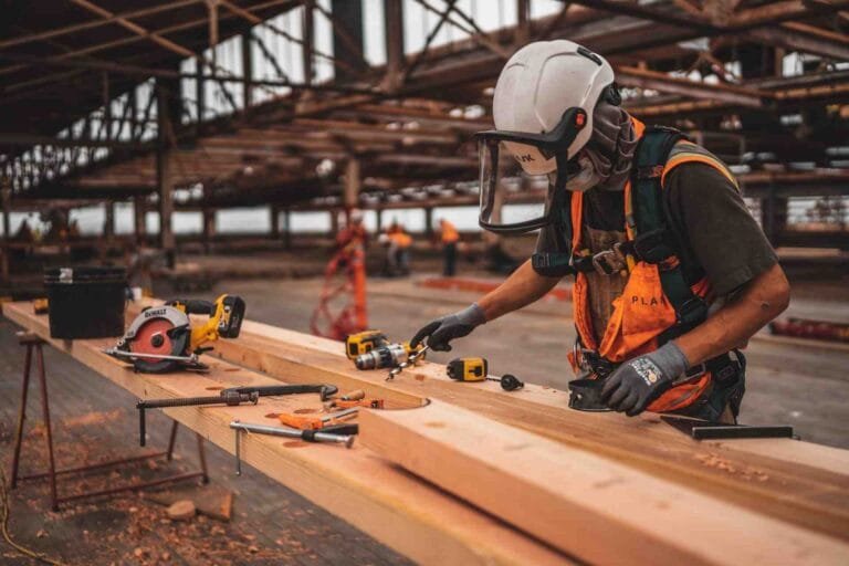 A man skillfully working on a wooden plank in a Cambodian factory, showcasing the need for Labor Market in Cambodian Construction.