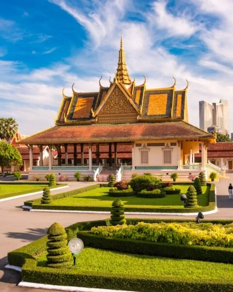 Real Estate Development in Cambodia: Traditional Cambodian palace with ornate golden roofs, landscaped gardens, and modern city backdrop.