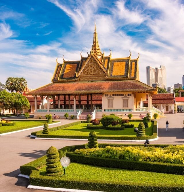 Real Estate Development in Cambodia: Traditional Cambodian palace with ornate golden roofs, landscaped gardens, and modern city backdrop.