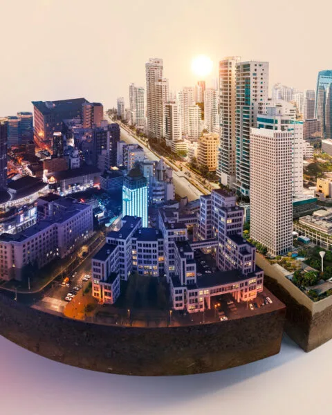 Cambodia Smart City Projects: A cityscape at sunset with buildings on a curved surface against a white background.