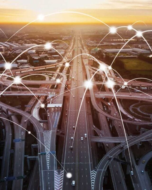 Aerial view of a bustling highway at sunset, overlaid with light connections depicting a networked transportation system to symbolise Cambodia Infrastructure Connectivity.