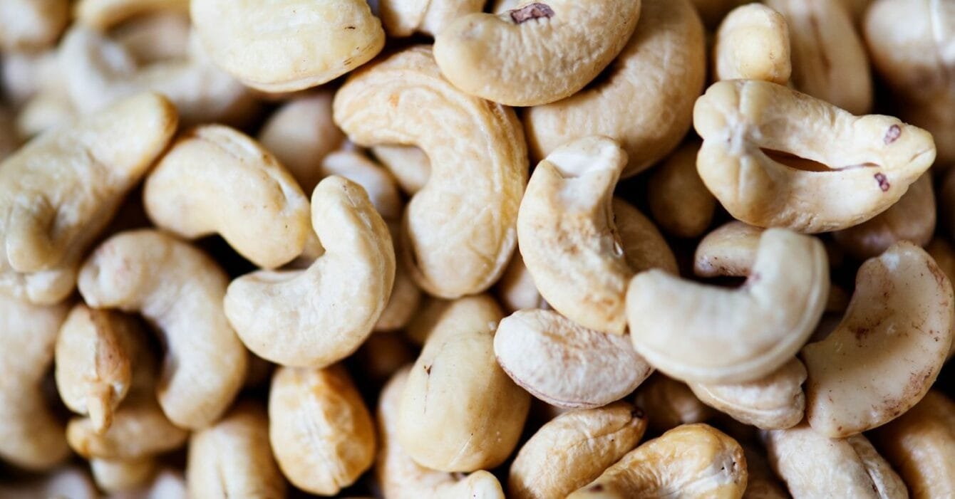 Cambodia cashew processing: A close-up image of a pile of raw cashew nuts, showcasing their creamy texture and curved shapes.