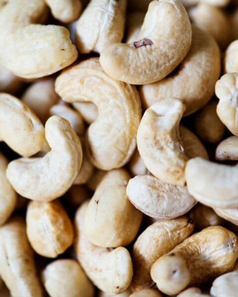 Cambodia cashew processing: A close-up image of a pile of raw cashew nuts, showcasing their creamy texture and curved shapes.